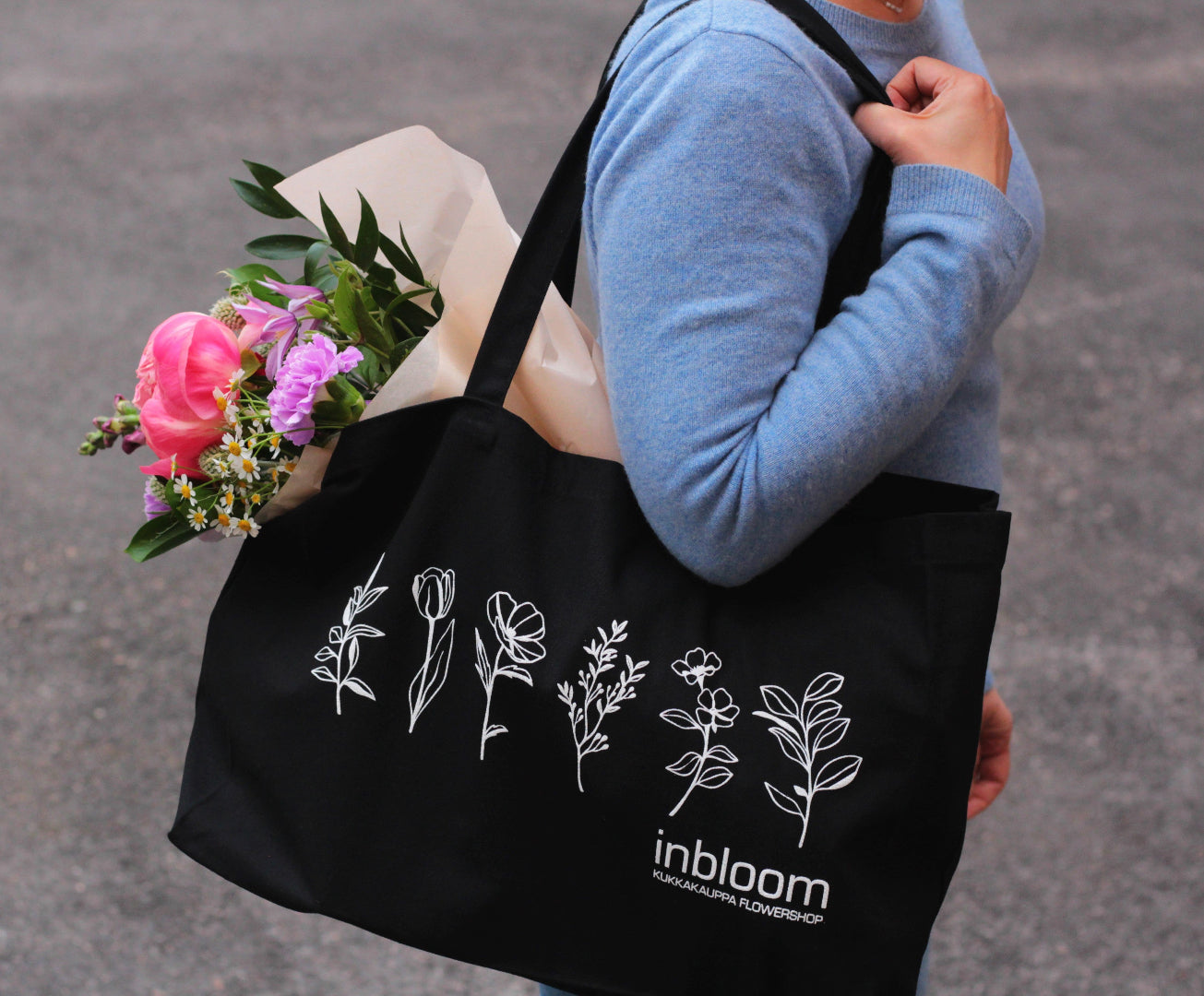 black cotton bag holding bouquet